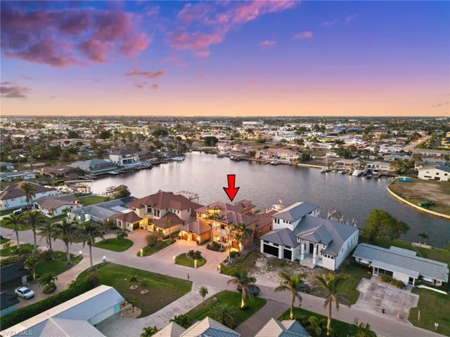 Aerial view at dusk featuring a water view