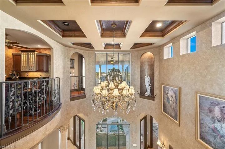 Details with ceiling fan with notable chandelier, coffered ceiling, ornamental molding, and beam ceiling
