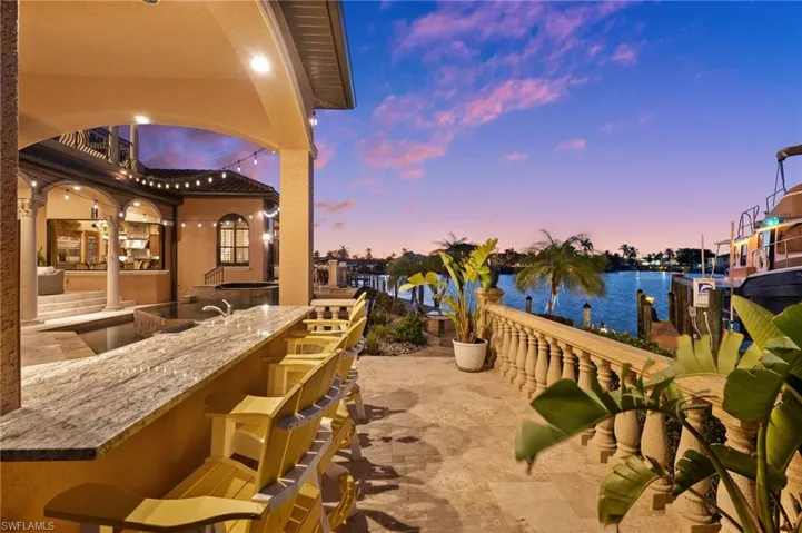 Patio terrace at dusk with a water view and a bar