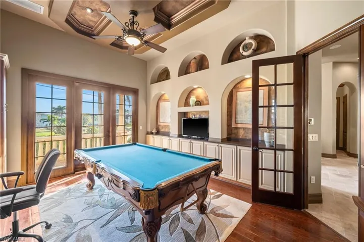Game room with built in shelves, ceiling fan, billiards, coffered ceiling, and dark hardwood / wood-style flooring