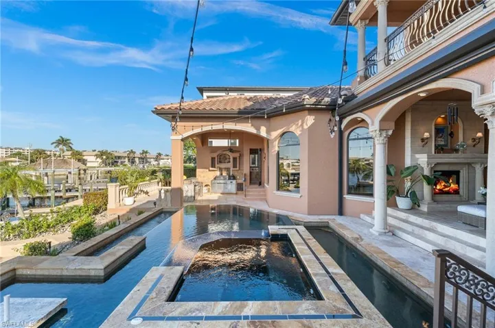 View of pool featuring a fireplace, a patio, and an in ground hot tub