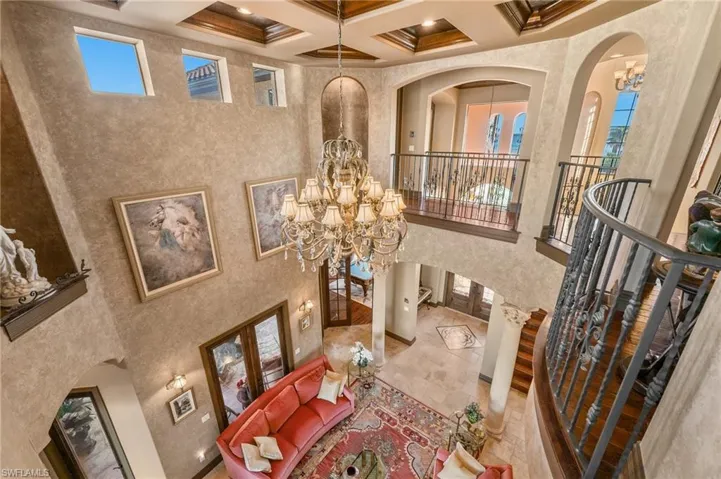 Dining area featuring coffered ceiling, an inviting chandelier, beamed ceiling, a towering ceiling, and french doors