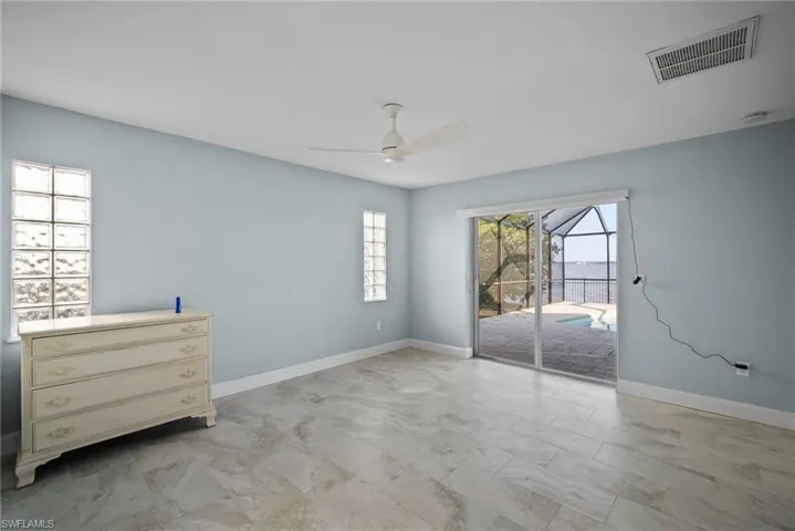 Unfurnished bedroom with ceiling fan and access to outside