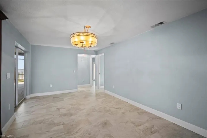 Empty room with an inviting chandelier and a textured ceiling