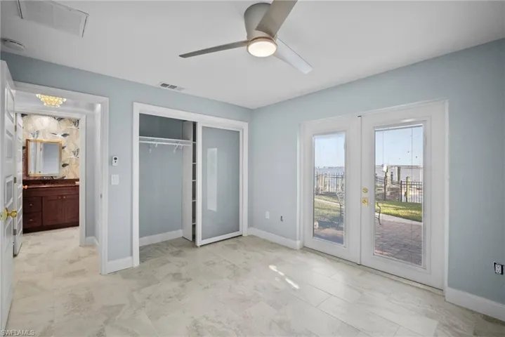 Unfurnished bedroom featuring french doors, ceiling fan, a closet, and access to outside