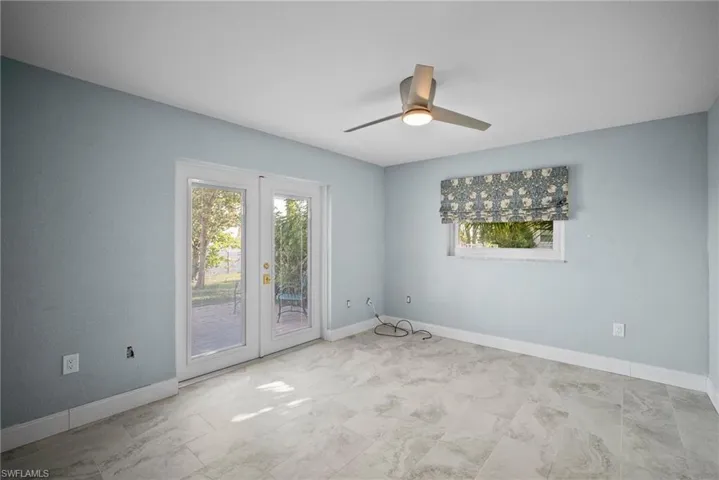 Empty room featuring french doors and ceiling fan