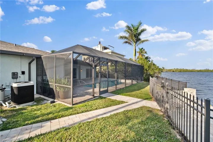 View of yard featuring a patio, a water view, and glass enclosure