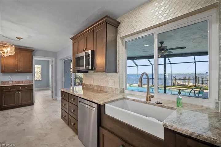 Kitchen featuring sink, a water view, a healthy amount of sunlight, and appliances with stainless steel finishes