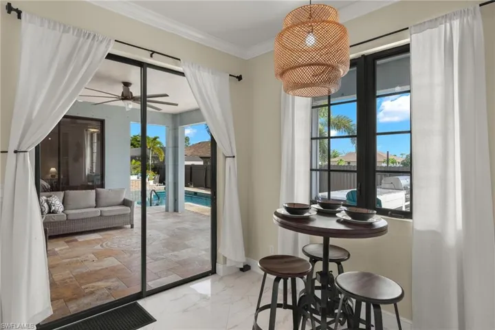 Doorway to outside featuring crown molding, ceiling fan, and tile patterned floors