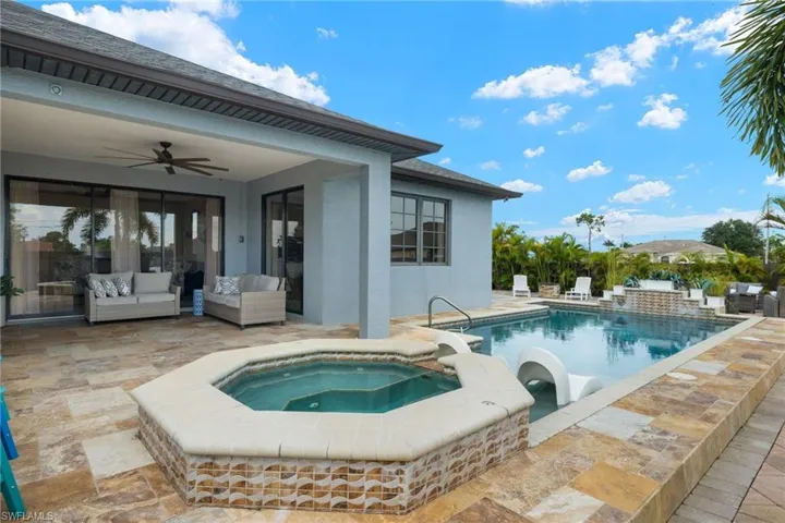 View of pool with an outdoor living space, a patio area, ceiling fan, and an in ground hot tub