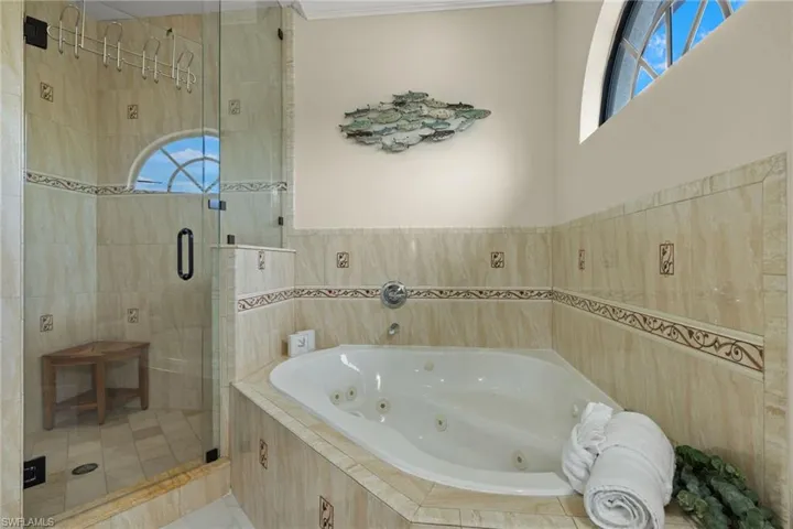 Bathroom with crown molding and shower with separate bathtub