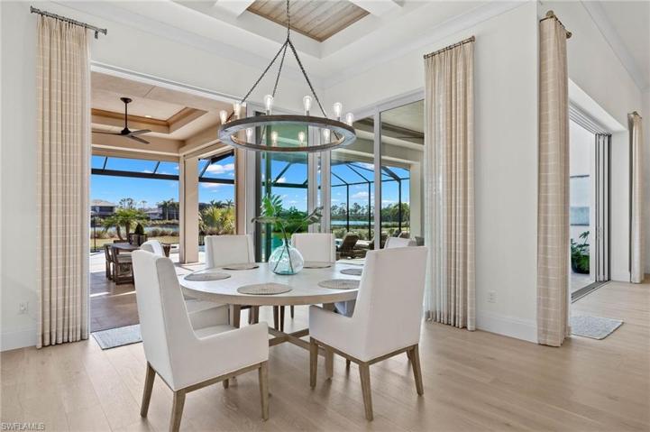 Modern Look in the Dining Space, Clean and Crisp! Lovely Water and Pool Views. The Room is Nicely Framed with the Custom Draperies.
