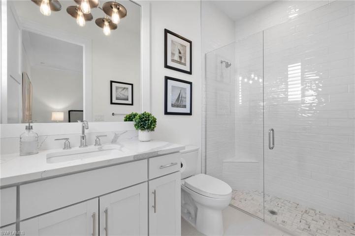 Edison Bulb Light Fixtures, Beautiful Tile Work, Framed Mirror.