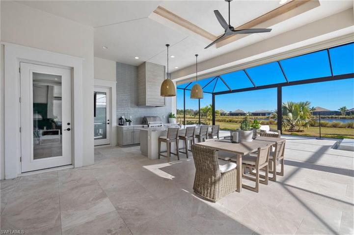 Shot of Outdoor Kitchen and Dining Space. Door on the Left leads to a Bedroom. Right Door to the Full Bath. Note the Crown, High End Fan and Lighting Fixtures.  Large Yard Beyond the Screens.