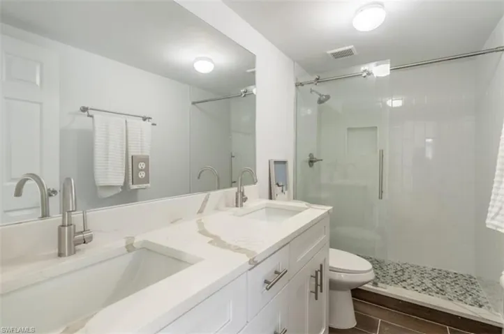 Bathroom with double vanity and a shower stall