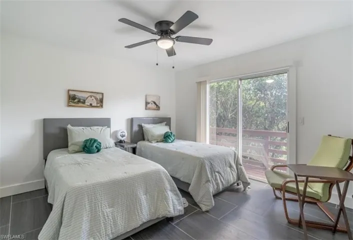 Bedroom with ceiling fan, access to outside, and wood tiled floors