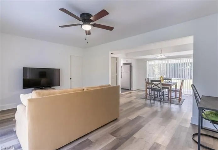 Living room with light wood-style flooring and ceiling fan