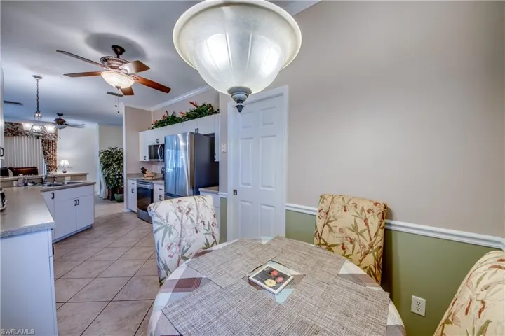 Dining space featuring light tile patterned flooring, crown molding, and ceiling fan