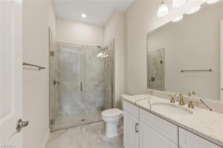 Full bath with a shower stall and vanity