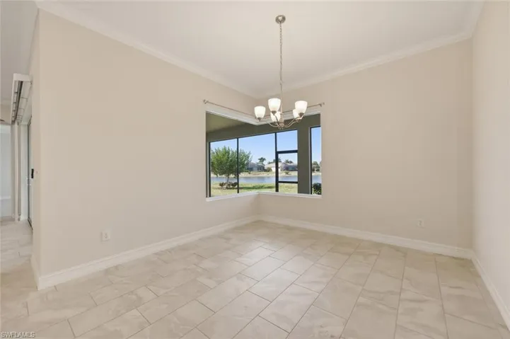 Spare room featuring hanging lights, ornamental molding, and a water view