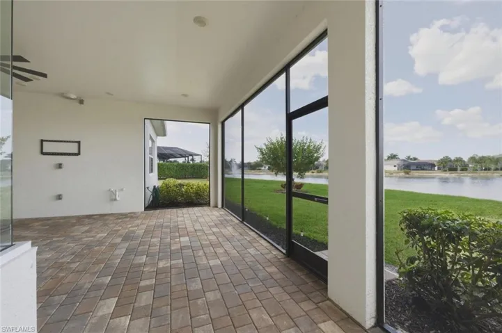 Unfurnished sunroom featuring a water view and ceiling fan