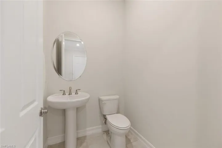 Half bathroom featuring toilet and baseboards