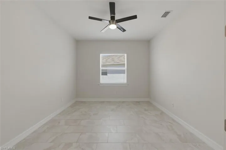 Empty room with a ceiling fan and baseboards
