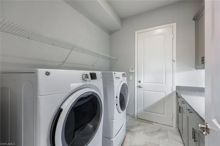 Laundry Room off Garage entrance, with Expansive- Full Capacity Quartz Folding Counter, Full Upper/Lower Storage Cabinetry, and Sink