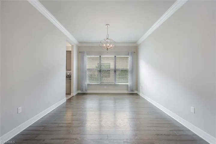 Formal Dining Room with Wood Flooring, Crown Molding and Chandelier