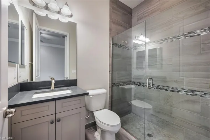 Secondary Bathroom's Onsuite Bathroom with Quartz Counters and Extended, Upgraded tile to Ceilings.