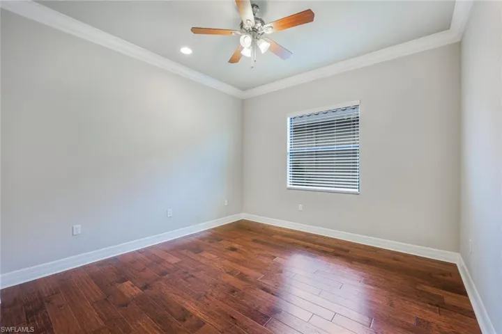 Secondary Bedroom with Wood Flooring and Crown Molding