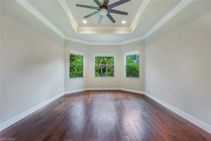 Master Suite with Wood Floors, Tray Ceilings, Crown Molding and View of Private Yard
