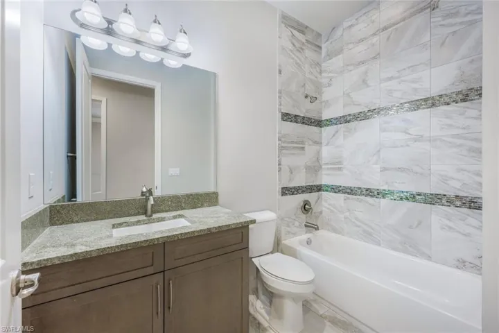 Secondary Bathroom with Quartz Counters and Extended, Upgraded Tile to Ceiling