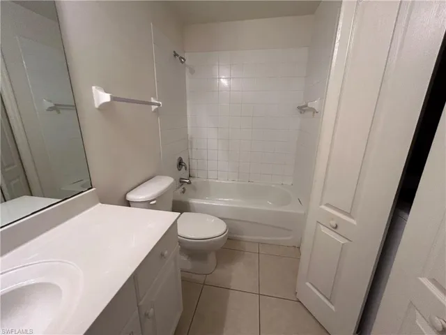 Bathroom with tile patterned floors, vanity, and shower / washtub combination