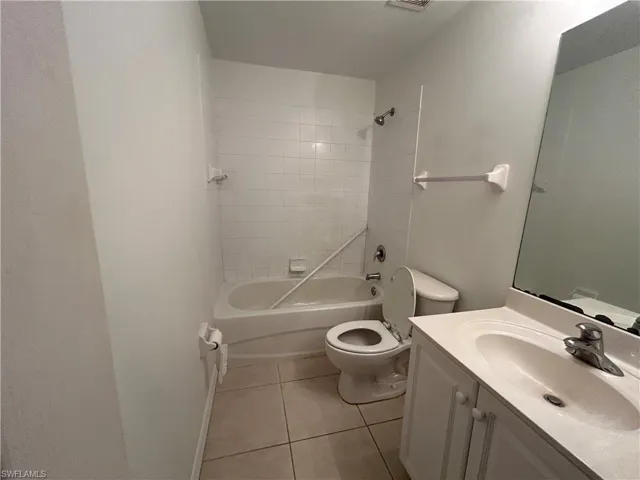 Bathroom with tile patterned flooring, vanity, and washtub / shower combination