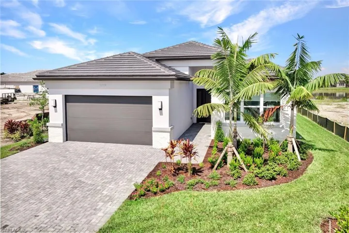 View of front of home featuring a front yard, a 2 car garage