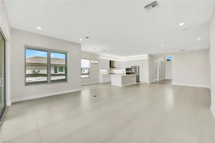 Unfurnished living room with light tile patterned flooring, and views of Dining area, Kitchen, and Breakfast Area