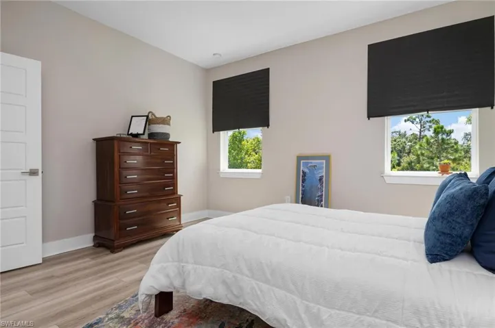Bedroom with light hardwood / wood-style flooring and multiple windows
