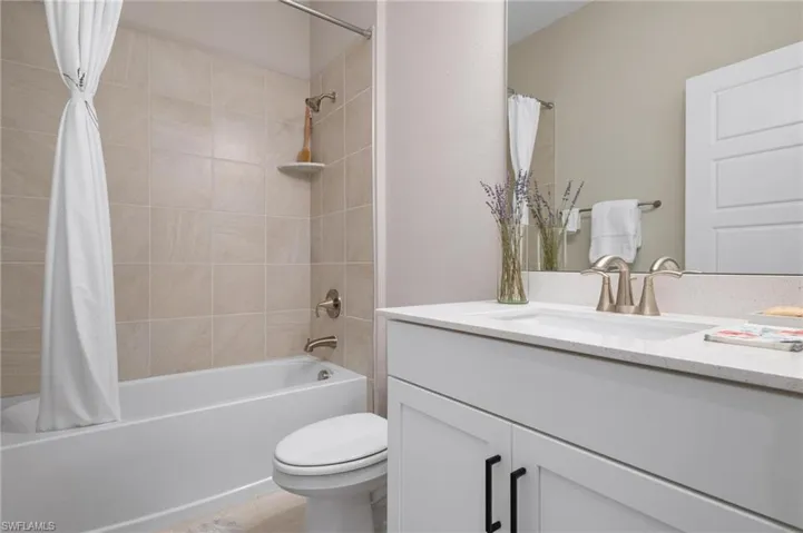 Full bathroom featuring toilet, vanity, and shower / bath combo with shower curtain