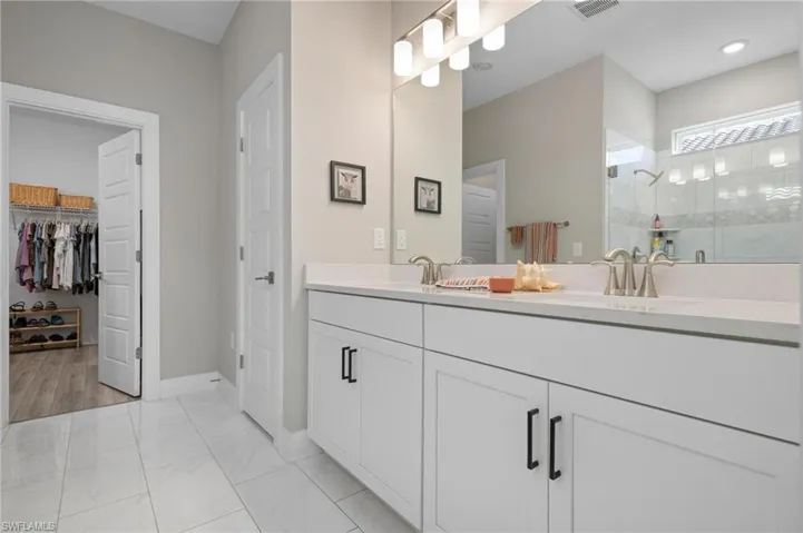 Bathroom with tile patterned flooring, vanity, and walk in shower
