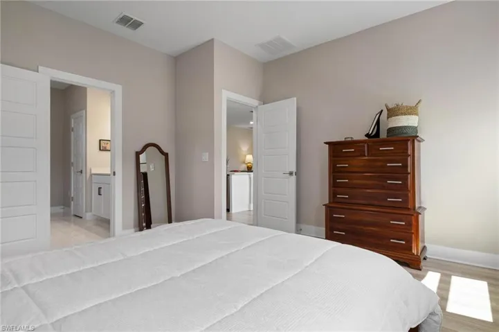 Bedroom featuring light wood-type flooring and ensuite bathroom