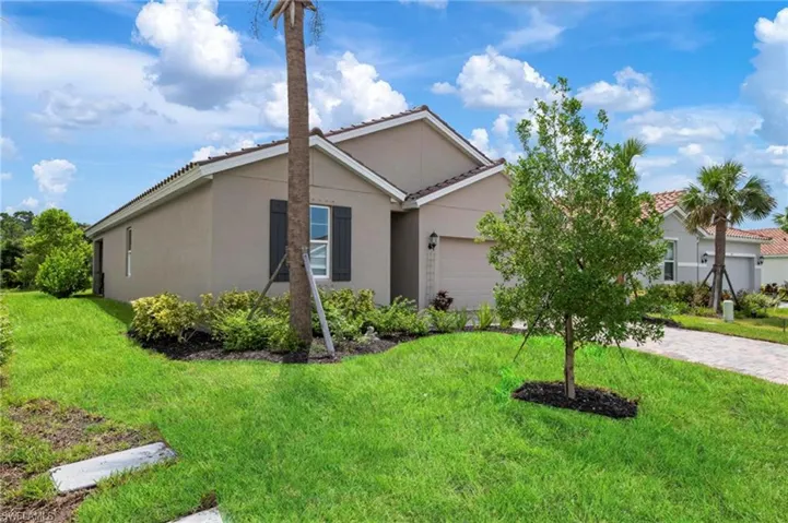 View of front of home featuring a front lawn and a garage