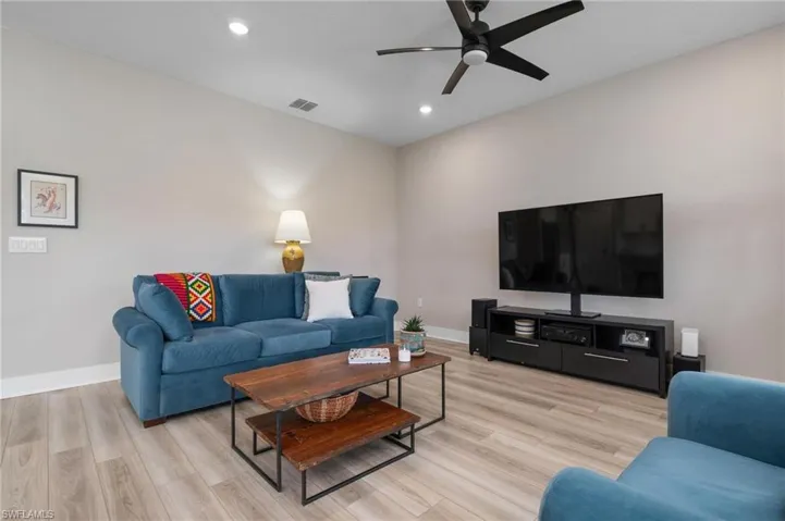 Living room with ceiling fan and light hardwood / wood-style floors