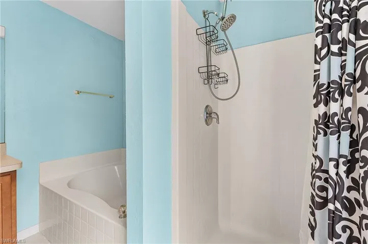 Full bathroom with vanity, a shower stall, and a garden tub