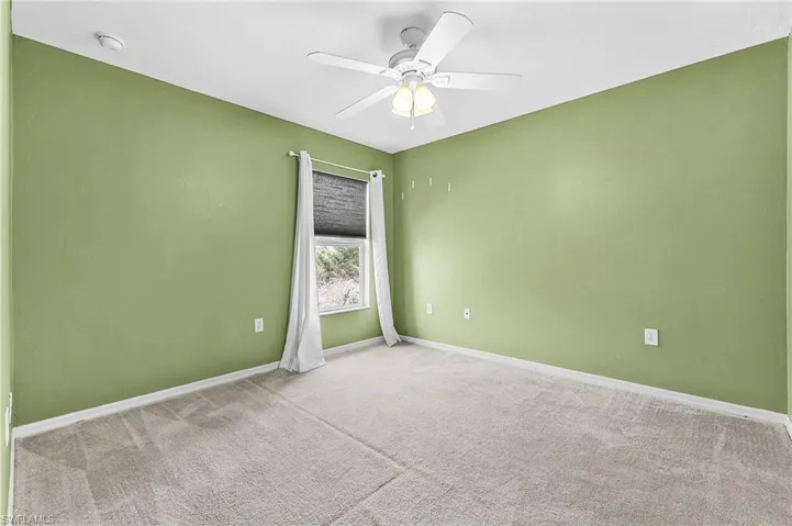 Spare room featuring light colored carpet and ceiling fan