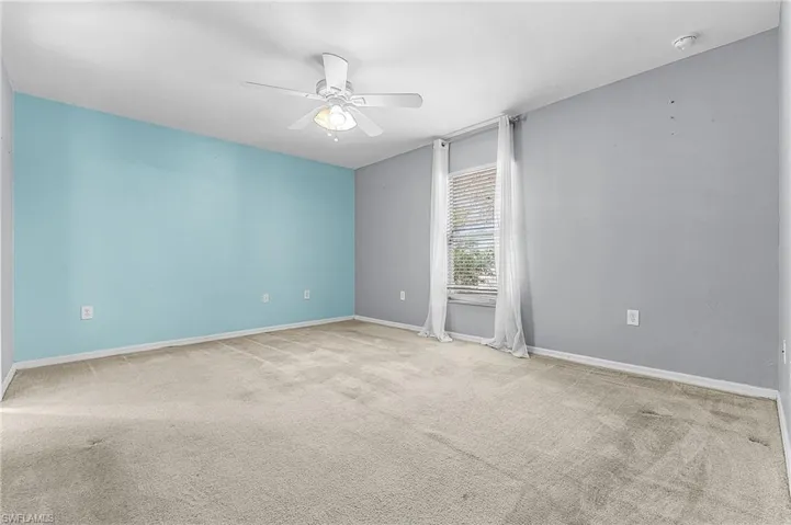 Unfurnished room with a ceiling fan and light colored carpet