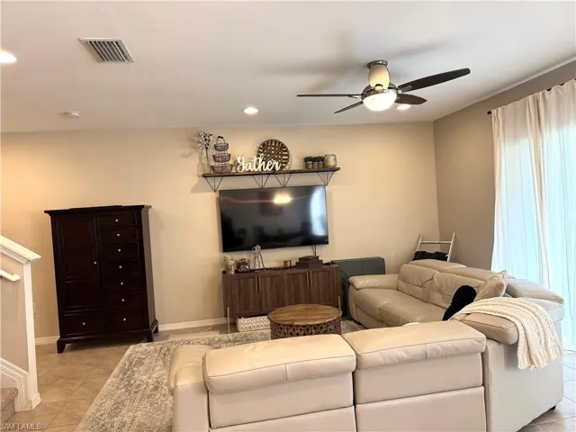 Tiled living room featuring ceiling fan