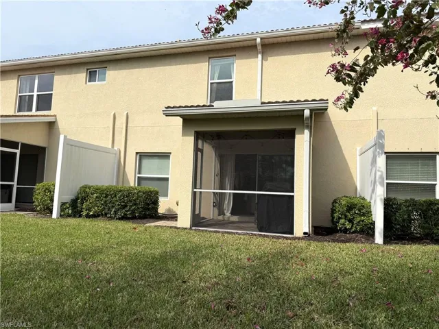Rear view of property with a sunroom and a yard