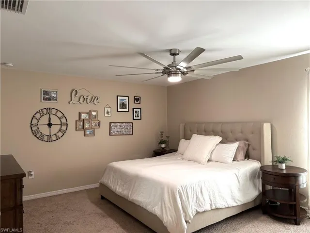 Carpeted bedroom featuring ceiling fan