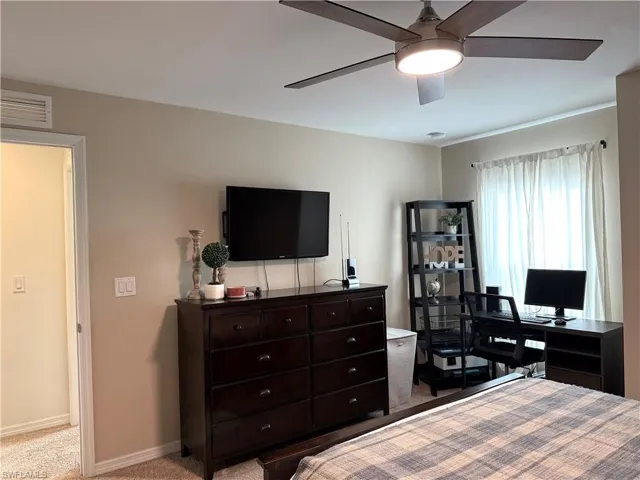 Carpeted bedroom featuring ceiling fan